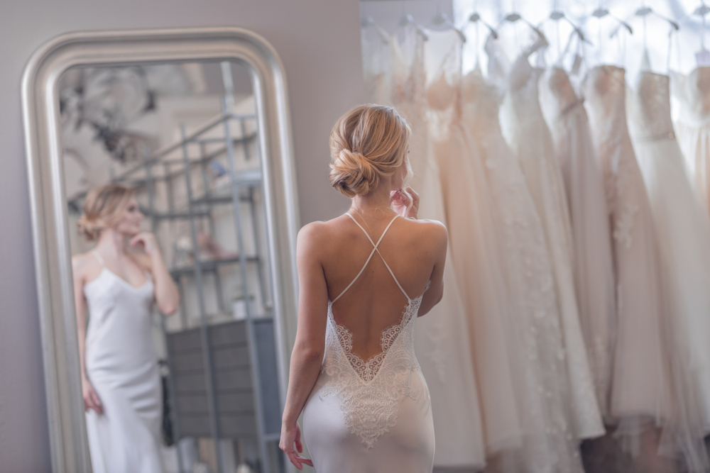 Attractive girl at the mirror in a wedding shop